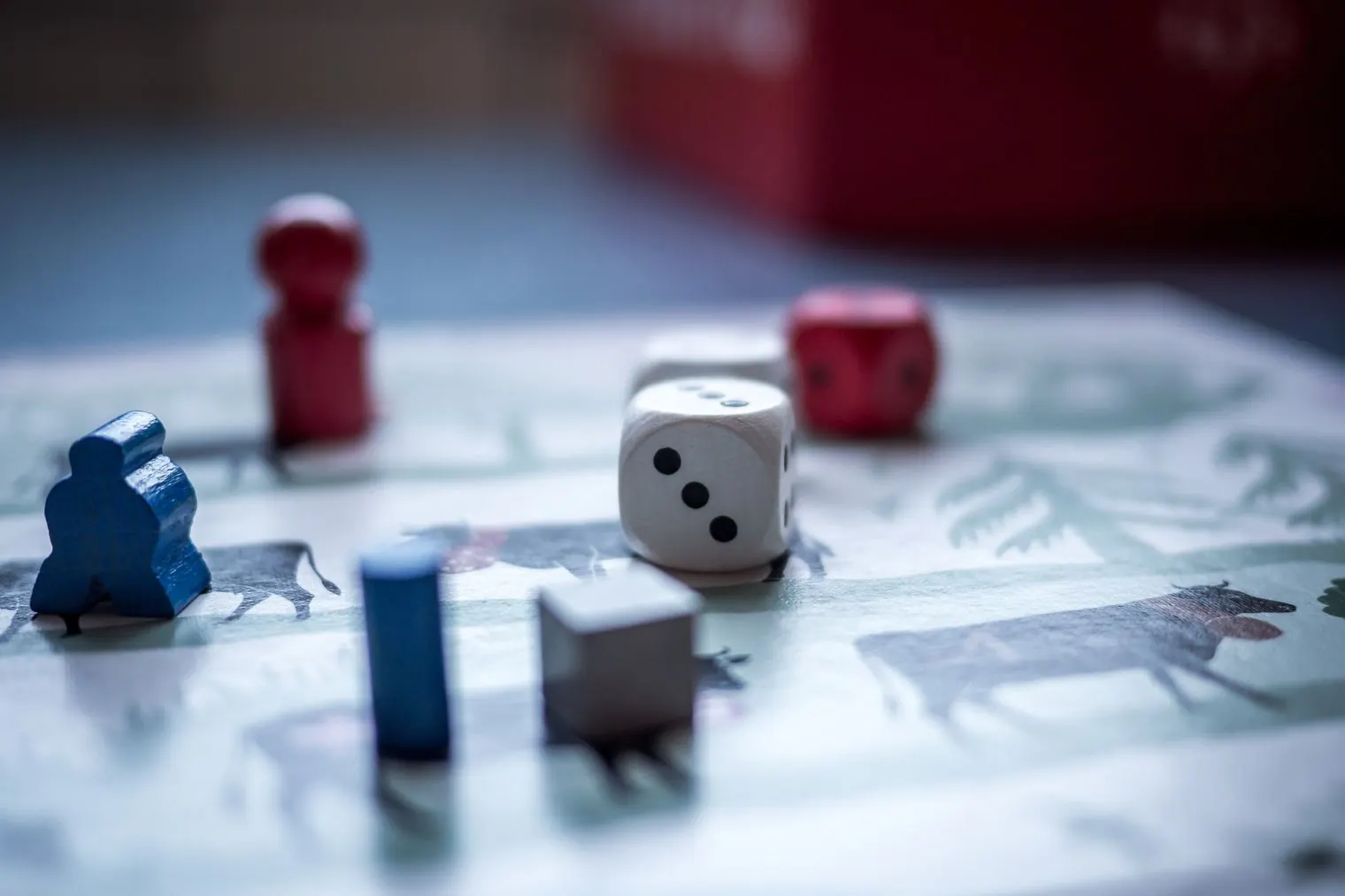 Board game pieces and a die on a game board