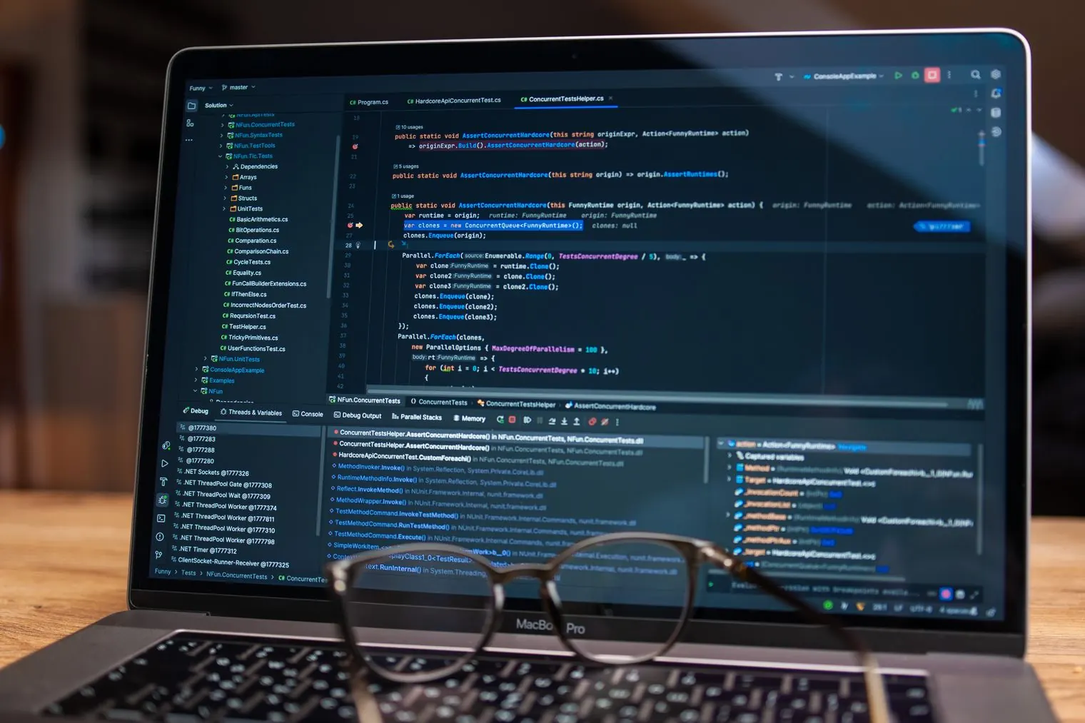 A laptop showing lines of code, with a pair of glasses resting on the keyboard