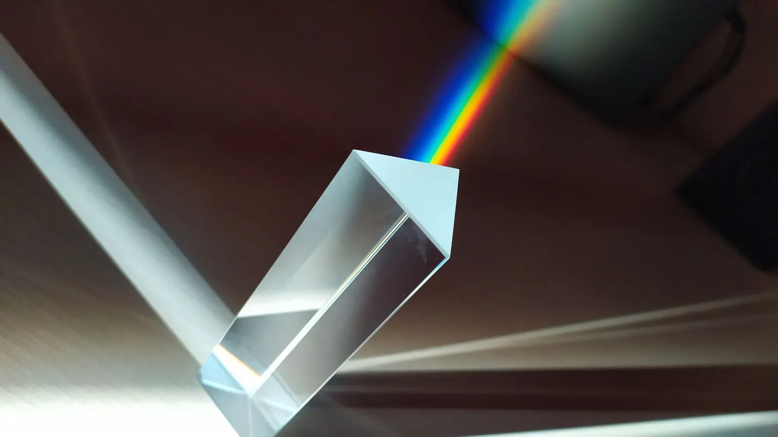 A glass prism splitting a beam of light into a rainbow