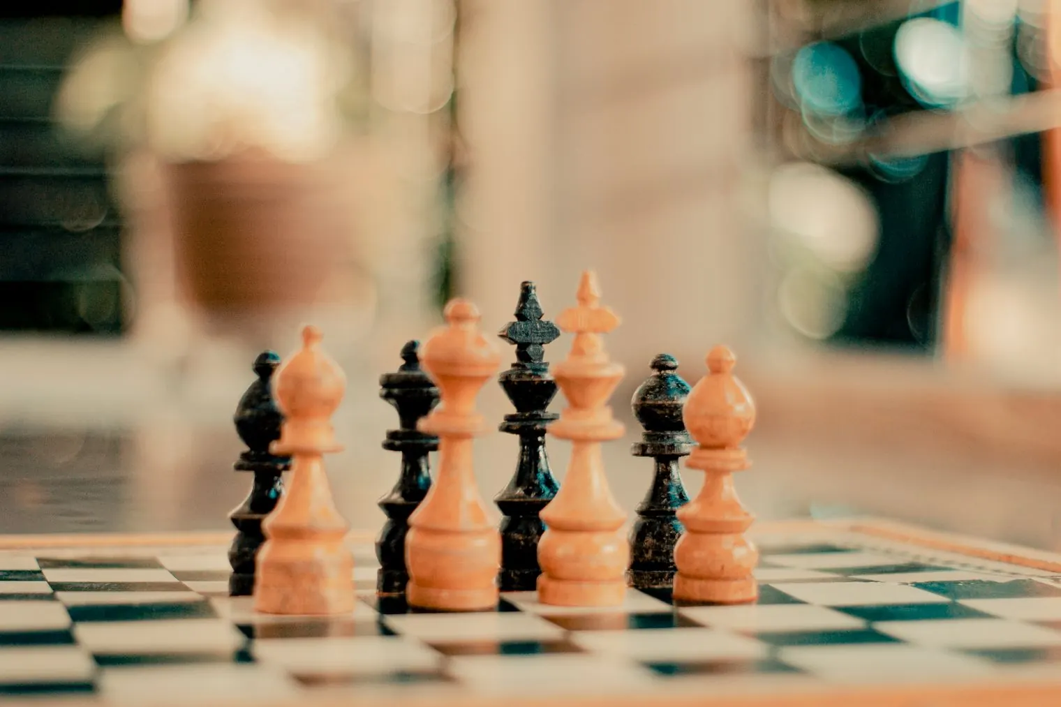 Chess pieces lined up on a board in warm afternoon light